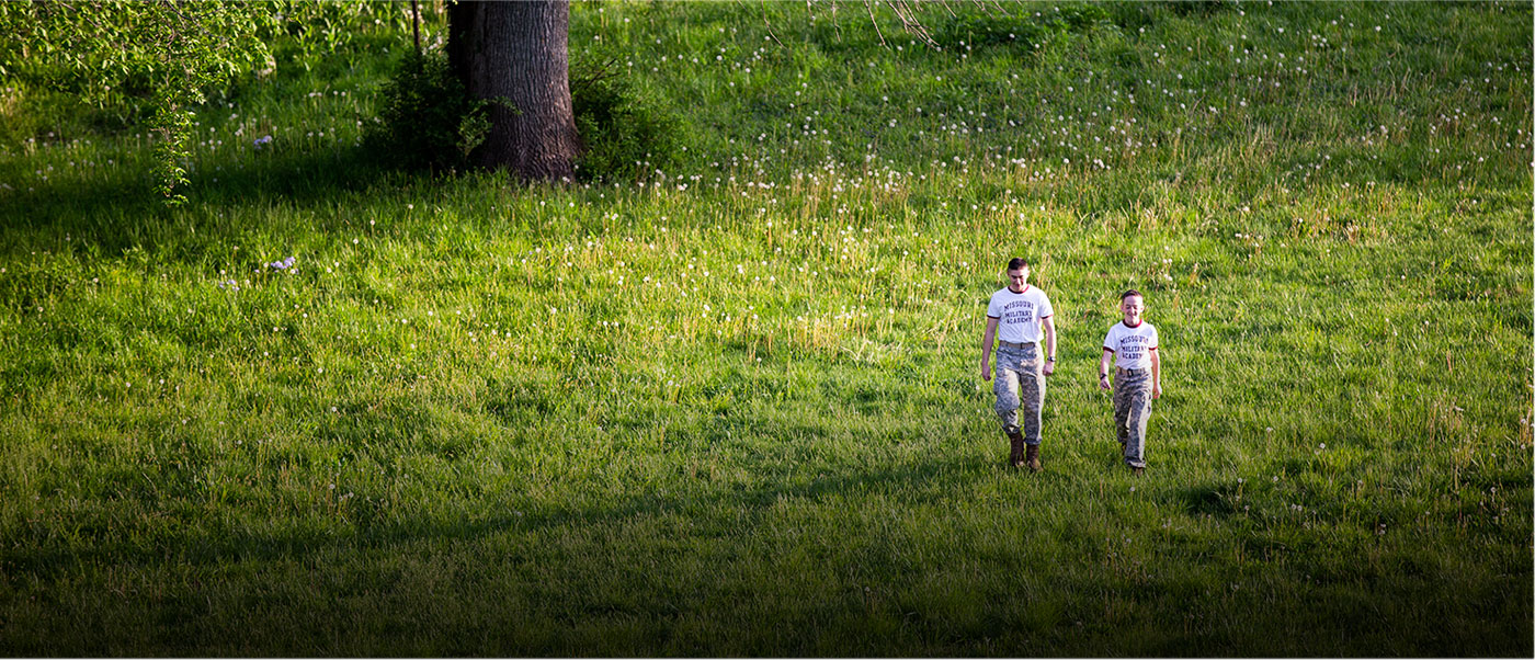 Two boys walking in an open field